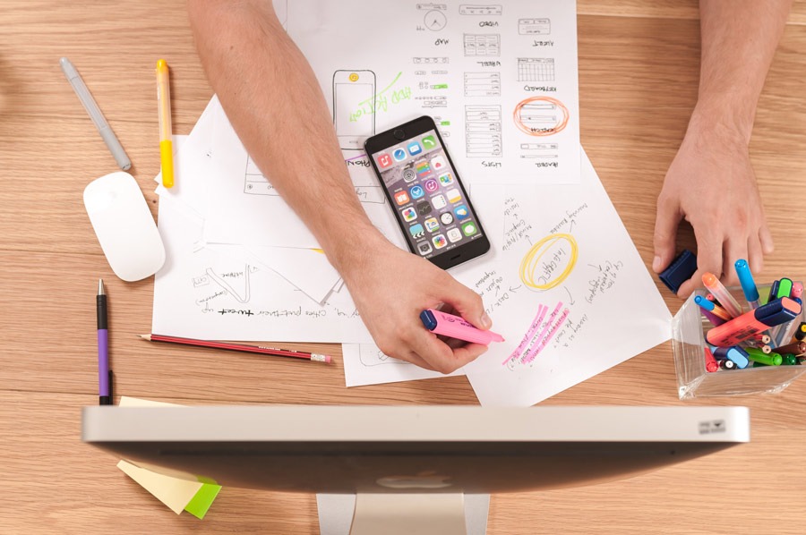 Kreatives Webdesign am Schreibtisch: Skizzen, Smartphone und Stifte. 7zwo MEDIA – Ihre Agentur für innovatives Marketing.