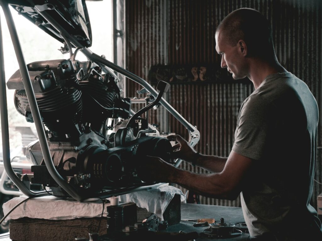 Mann arbeitet konzentriert an einem Motorradmotor in einer Werkstatt – Präzision und Handwerkskunst bei 7zwo MEDIA.