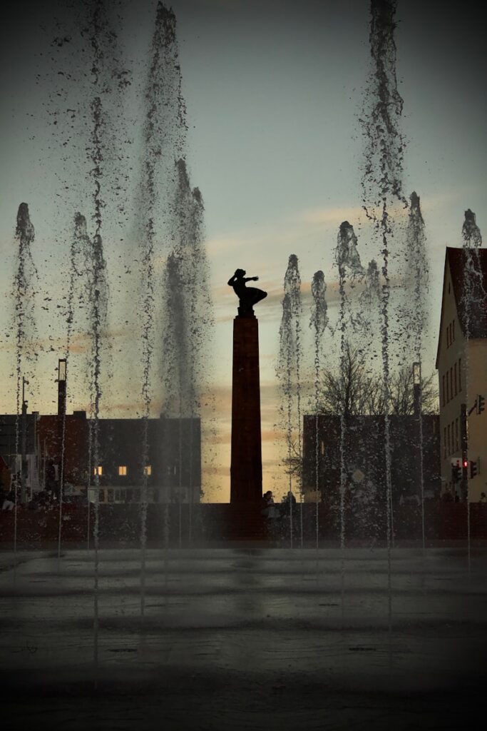 Brunnen mit stilvoller Statue bei Sonnenuntergang: Perfekte Harmonie aus Kunst und Natur für kreative Inszenierungen.